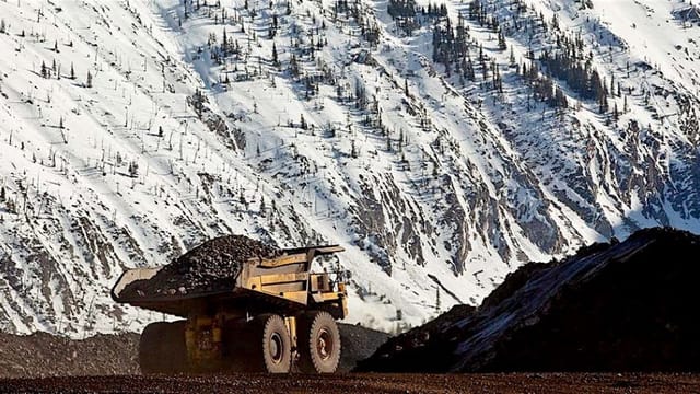 A haul truck at a British Columbia mine below a snow-covered mountain